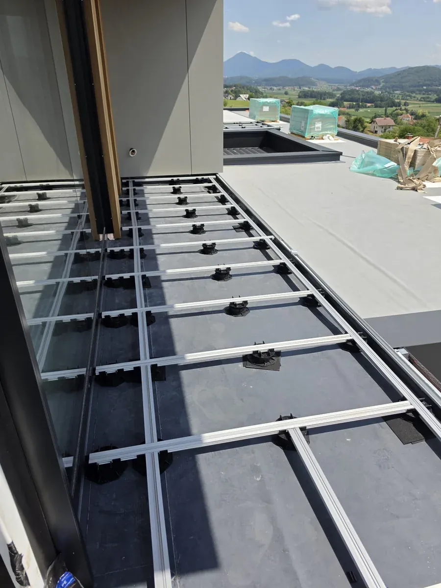 Pedestal grid along the timber screen edge at a Slovenia mansion rooftop with spirit level