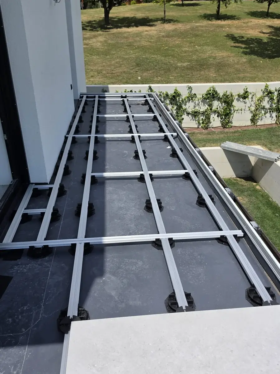 Pedestal grid running along the rooftop edge above the planted vine strip at a Slovenia mansion